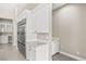 Modern kitchen with stainless steel refrigerator, white cabinets, and a built-in desk area at 10016 Copper Edge Rd, Las Vegas, NV 89148