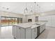 Open-concept kitchen with island and sink featuring quartz countertops, white cabinets, and stainless steel appliances at 10016 Copper Edge Rd, Las Vegas, NV 89148