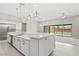 Modern kitchen island with stainless steel appliances, white cabinets, and sleek pendant lighting at 10016 Copper Edge Rd, Las Vegas, NV 89148