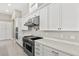 Gourmet kitchen with stainless steel appliances, white cabinets, quartz counters, and a pot filler over the stove at 10016 Copper Edge Rd, Las Vegas, NV 89148