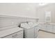 Well-lit laundry room with sink, quartz countertops, cabinets and front loading washer and dryer at 10016 Copper Edge Rd, Las Vegas, NV 89148