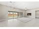 Open living room with tile flooring, a contemporary light fixture, and large sliding glass doors to the yard at 10016 Copper Edge Rd, Las Vegas, NV 89148