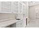 This mudroom features white cabinets, a countertop with a sink, and view to the entrance of a bathroom at 10016 Copper Edge Rd, Las Vegas, NV 89148