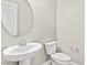 Elegant powder room showcasing a pedestal sink, oval mirror, and modern toilet at 10016 Copper Edge Rd, Las Vegas, NV 89148