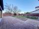 A well-maintained backyard featuring grass, pavers, rock landscaping, and a brick perimeter wall at 10105 Prattville Ave, Las Vegas, NV 89148