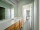 Bathroom features oak vanity, large mirror, and oak vinyl floor at 10105 Prattville Ave, Las Vegas, NV 89148