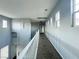 Long upstairs hallway with multiple windows and railing at 10105 Prattville Ave, Las Vegas, NV 89148