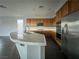 Kitchen island with white countertop and sink, framed by wood cabinets, and stainless-steel appliances at 10105 Prattville Ave, Las Vegas, NV 89148