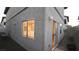 View of a house's side wall, featuring a small patio, turf, and exterior lighting at 10596 Corte Sierra St, Las Vegas, NV 89183