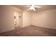 Bedroom featuring neutral carpet, a ceiling fan, an entry door and a bathroom door at 10596 Corte Sierra St, Las Vegas, NV 89183