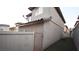 View of a house's side wall, featuring a small gate, turf, and tiled roof at 10596 Corte Sierra St, Las Vegas, NV 89183