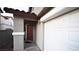 View of the wood front door, covered entry, and portion of the two-car garage at 10596 Corte Sierra St, Las Vegas, NV 89183