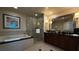 Well-lit bathroom featuring a soaking tub, glass enclosed shower, and double sink vanity with dark wood cabinets at 135 E Harmon Ave # 307, Las Vegas, NV 89109