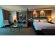 Comfortable bedroom with a king-sized bed, seating area, and stylish decor with warm lighting at 135 E Harmon Ave # 307, Las Vegas, NV 89109