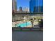 Balcony view of a sunny outdoor pool area with lounge chairs and palm trees, surrounded by city buildings at 135 E Harmon Ave # 307, Las Vegas, NV 89109
