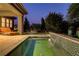 Backyard pool and patio with lounge chairs and greenery at dusk at 15 Reflection Bay Dr, Henderson, NV 89011