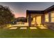 Backyard at dusk featuring a water feature, covered patio and seating area at 15 Reflection Bay Dr, Henderson, NV 89011