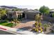 Beautiful home with a stone facade, desert landscaping, and a brick driveway at 15 Reflection Bay Dr, Henderson, NV 89011