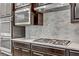 Close-up of kitchen featuring stainless steel appliances, tile backsplash, and granite countertops at 15 Reflection Bay Dr, Henderson, NV 89011