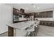 Kitchen island with breakfast bar seating, stainless steel appliances, and dark wood cabinets at 15 Reflection Bay Dr, Henderson, NV 89011