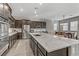 Kitchen view featuring a large granite island, stainless steel appliances, and dark wood cabinetry at 15 Reflection Bay Dr, Henderson, NV 89011