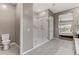 Elegant main bathroom with neutral tones, a walk-in shower, and a view of the main bedroom at 15 Reflection Bay Dr, Henderson, NV 89011