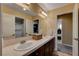 Bathroom featuring double sinks, tile countertops, and access to shower and laundry room at 1883 Nature Park Dr, North Las Vegas, NV 89084