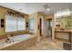 Inviting bathroom with a soaking tub, tile surround, and a large window offering natural light at 1883 Nature Park Dr, North Las Vegas, NV 89084