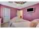 Bedroom showcasing a statement light fixture, television, and connecting bathroom access at 1883 Nature Park Dr, North Las Vegas, NV 89084