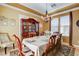 Formal dining room with elegant chandelier, wood furniture, and a beautiful china cabinet at 1883 Nature Park Dr, North Las Vegas, NV 89084