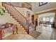 Elegant foyer with a grand staircase, rich wood banister, and views into the open living areas at 1883 Nature Park Dr, North Las Vegas, NV 89084