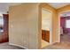 Hallway view that reveals neutral paint, and doorways to the bedrooms and laundry room at 1883 Nature Park Dr, North Las Vegas, NV 89084