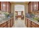 Bright kitchen featuring granite counters, tile backsplash and view into dining area at 1883 Nature Park Dr, North Las Vegas, NV 89084