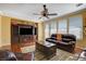 Living room featuring comfortable leather sofas, a ceiling fan, and a large TV at 1883 Nature Park Dr, North Las Vegas, NV 89084