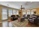 Spacious living room featuring hardwood floors, comfortable leather seating, and a ceiling fan at 1883 Nature Park Dr, North Las Vegas, NV 89084