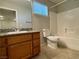 A bathroom featuring a vanity with a granite countertop, a mirror, a toilet, and a shower/tub combination at 2037 Houdini St, Henderson, NV 89002