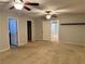 Large bedroom with two ceiling fans, carpet, three doors, and an open doorway to another room at 2037 Houdini St, Henderson, NV 89002