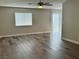 Neutral living room filled with light, featuring wood-look flooring, window, and ceiling fan at 2037 Houdini St, Henderson, NV 89002