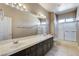 Bathroom features double sinks, dark cabinets, and shower-tub combo with glass doors at 21 Bridal Falls Ct, Las Vegas, NV 89148