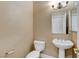 Cozy powder room featuring a pedestal sink, a white toilet, and a decorative mirror at 21 Bridal Falls Ct, Las Vegas, NV 89148