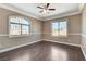 Well-lit bedroom with wood floors, chair rail, and windows overlooking trees at 21 Bridal Falls Ct, Las Vegas, NV 89148