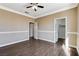 Bedroom with neutral color walls, crown molding, wood-like floors, and three doors at 21 Bridal Falls Ct, Las Vegas, NV 89148