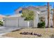 Inviting two-story home with a gated entrance, three-car garage, and desert landscaping at 21 Bridal Falls Ct, Las Vegas, NV 89148