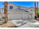 Two-story home featuring a three-car garage, gated entry, and desert landscaping at 21 Bridal Falls Ct, Las Vegas, NV 89148