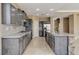 Spacious kitchen featuring gray cabinets, a granite countertop island, and tile flooring at 21 Bridal Falls Ct, Las Vegas, NV 89148