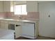 Kitchen featuring white appliances and cabinets with a pink tile backsplash at 224 S Wallace Dr, Las Vegas, NV 89107