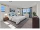 A staged main bedroom with multiple windows, natural light, and a patterned rug at 2300 Trasimeno Pl, Henderson, NV 89044