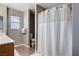 Clean bathroom featuring a shower with white curtain, warm wood-look floors and vanity at 262 Calvino Ave, Las Vegas, NV 89183