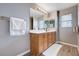 Bright bathroom featuring a large vanity with double mirrors and warm wood-look floors at 262 Calvino Ave, Las Vegas, NV 89183