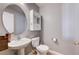 Powder room featuring a pedestal sink and commode with a decorative mirror at 262 Calvino Ave, Las Vegas, NV 89183